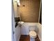 Small bathroom with brick wall and white wainscoting at 7527 Old Shelby Rd, Vale, NC 28168