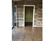 Bedroom featuring wood paneled walls, hardwood floors, closet, and access to the rear deck at 7527 Old Shelby Rd, Vale, NC 28168
