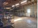 Large garage with shelving and exposed wooden beam ceiling at 7527 Old Shelby Rd, Vale, NC 28168