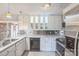Bright kitchen with white cabinets, marble countertops, stainless steel backsplash and appliances at 7527 Old Shelby Rd, Vale, NC 28168