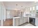 Well-lit kitchen and dining area with white cabinets, marble countertops, and hardwood floors at 7527 Old Shelby Rd, Vale, NC 28168