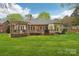Exterior showcasing a spacious deck, lush lawn, and the home's brick facade under a sunny sky at 7626 Vistaview Dr, Cornelius, NC 28031