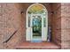 Close-up of a welcoming front door with a charming arched window, brick surround, and welcome sign at 7626 Vistaview Dr, Cornelius, NC 28031
