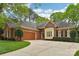 A beautiful brick home with a well-manicured lawn, a driveway, and mature trees at 7626 Vistaview Dr, Cornelius, NC 28031