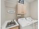 Well-equipped laundry room with sink, washer, dryer, and storage cabinets at 7626 Vistaview Dr, Cornelius, NC 28031