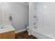 Modern bathroom with white tile, wood floors, sink, and a shower-tub combo at 7748 Long Bay Pkwy, Catawba, NC 28609