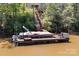 Dock with covered boat slip and stairs leading to the home, surrounded by lush trees on the lake at 7748 Long Bay Pkwy, Catawba, NC 28609