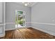 Bright, empty room with natural light, crown molding, and pristine hardwood floors at 7748 Long Bay Pkwy, Catawba, NC 28609
