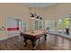 Game room with pool table, three pendant lights, windows, and wood floors at 7748 Long Bay Pkwy, Catawba, NC 28609