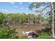 Scenic view of the lake surrounded by lush trees, featuring a dock with a covered boat slip at 7748 Long Bay Pkwy, Catawba, NC 28609