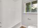Full bath with tiled shower and tub with a light and airy window at 801 Bilmark Ave, Charlotte, NC 28213
