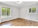 This bedroom features gleaming hardwood floors, a neutral paint and multiple window views at 801 Bilmark Ave, Charlotte, NC 28213