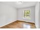 This bright bedroom features gleaming hardwood floors, a neutral paint and view of the neighborhood at 801 Bilmark Ave, Charlotte, NC 28213