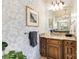 A lovely bathroom featuring floral wallpaper, granite countertops, and a well-lit vanity mirror with dark wood cabinetry at 9200 Kingsmead Ln, Waxhaw, NC 28173