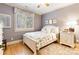 A cozy bedroom with a floral bedding, a bright window with white shutters and hardwood flooring at 9200 Kingsmead Ln, Waxhaw, NC 28173