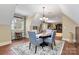 Open concept dining room with a round table, four chairs, a chandelier, and hardwood floors at 9200 Kingsmead Ln, Waxhaw, NC 28173
