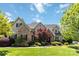 Stunning stone and stucco home with a lush, landscaped front yard on a sunny day at 9200 Kingsmead Ln, Waxhaw, NC 28173