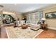 Spacious living room with a large sectional sofa, an ottoman, and a decorative rug on hardwood floors at 9200 Kingsmead Ln, Waxhaw, NC 28173