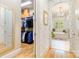 Spacious walk-in closet with organized shelving, and a peek into a bathroom with a garden tub at 9200 Kingsmead Ln, Waxhaw, NC 28173
