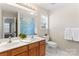 Bright bathroom featuring double sinks, a decorative shower curtain, and a window for natural light at 9715 Aragorn Nw Ln, Charlotte, NC 28269