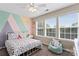 Bright bedroom with a ceiling fan, two windows, and a colorful accent wall at 9715 Aragorn Nw Ln, Charlotte, NC 28269