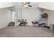 Open bonus room with a ceiling fan, games and access to stairs at 9715 Aragorn Nw Ln, Charlotte, NC 28269