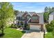 A two-story brick house with a well-kept lawn, a basketball hoop, and a two-car garage on a sunny day at 9715 Aragorn Nw Ln, Charlotte, NC 28269