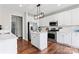 Modern kitchen with white cabinets, stainless steel appliances, and a center island at 9715 Aragorn Nw Ln, Charlotte, NC 28269