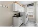 Functional laundry room with white cabinets, a black countertop, and stylish patterned floors at 9715 Aragorn Nw Ln, Charlotte, NC 28269