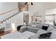 Bright living room featuring stairs leading to second floor and an oversized sectional sofa at 9715 Aragorn Nw Ln, Charlotte, NC 28269