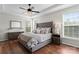 Beautiful main bedroom featuring a tufted headboard, tray ceiling, and a modern ceiling fan with a crystal-style light at 9715 Aragorn Nw Ln, Charlotte, NC 28269