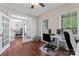 Home office showcasing hardwood floors, two workstations, and a view into the adjacent dining area through French doors at 9715 Aragorn Nw Ln, Charlotte, NC 28269