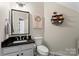 Charming powder room with a black granite countertop, patterned floors, and elegant decor at 9715 Aragorn Nw Ln, Charlotte, NC 28269
