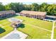 Aerial view of condo complex with swimming pools, lawn, and mature trees at 103 Carriage House Dr, Kannapolis, NC 28081