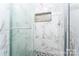 Shower with glass doors, marble tiles, and mosaic niche at 103 Carriage House Dr, Kannapolis, NC 28081