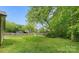 Large, grassy backyard enclosed by a wooden fence and mature trees at 10340 Williams Rd, Mint Hill, NC 28227