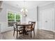 Cozy dining area with a classic chandelier, a window with natural light, and stylish wood-look floors at 10340 Williams Rd, Mint Hill, NC 28227