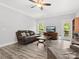 Relaxing living room features wood-look flooring, a ceiling fan, and a view to a fenced backyard at 10340 Williams Rd, Mint Hill, NC 28227