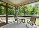 Relaxing screened-in porch with a table, chairs and a wooded backyard view at 10340 Williams Rd, Mint Hill, NC 28227