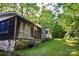 Side view of a charming wooden home featuring a stone foundation, nestled in a lush, green landscape at 1042 Jackson Rd, Fort Lawn, SC 29714