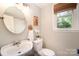 This bathroom has a sink with a round mirror, toilet, artwork and window at 106 Friendfield Dr # B, Fort Mill, SC 29715