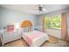 Bedroom features white furniture, pink accents, and a stylish rattan headboard, all illuminated by natural light at 106 Friendfield Dr # B, Fort Mill, SC 29715