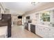 Kitchen with white cabinetry, black appliances, and door to the outdoor patio for easy access at 106 Friendfield Dr # B, Fort Mill, SC 29715