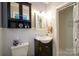 Neat and tidy bathroom with white wainscoting, a dark vanity, and a walk-in shower at 1081 Deas St, Rock Hill, SC 29732