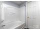 White bathtub and shower with a molded surround and modern fixtures, adjacent to bathroom door at 1119 Highway 218 W Hwy, Indian Trail, NC 28079