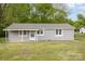 Charming single-story home with gray siding, a covered front porch and well-maintained lawn at 1119 Highway 218 W Hwy, Indian Trail, NC 28079
