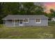 Charming single-story home with gray siding, a covered front porch and well-maintained lawn at 1119 Highway 218 W Hwy, Indian Trail, NC 28079