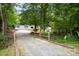 Home's driveway leading to a well-maintained home surrounded by lush greenery and mature trees at 114 Oakland Rd, Belmont, NC 28012