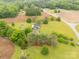 Secluded home with outbuildings is surrounded by trees and farmland in a rural setting at 1162 E Doc Garris Rd, Lancaster, SC 29720
