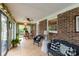 Inviting sunroom with brick accent wall, tile floor, and sliding doors to the backyard at 1162 E Doc Garris Rd, Lancaster, SC 29720